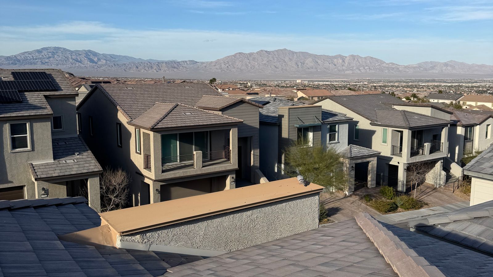 Tile-roofed homes in a desert subdivision under a clear sky